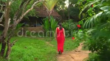 那个女人去了岛上的平房。 穿红衣服的美丽女子漫步热带花园